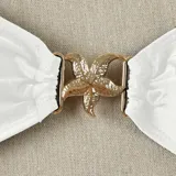 Top de bikini blanco con tirantes finos y detalle de estrella dorada en el centro.
