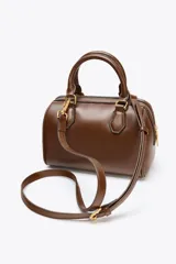 Bolso marrón formato city con asa doble de mano con detalles metálicos y correa interior extraíble en tejido canvas con posición bandolera. Bolsillo interior con cierre mediante cremallera metálica.