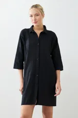 Túnica negra con bordados y bolsillos laterales.