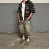 Camisa marrón a cuadros con botones, corte boxy y mangas cortas.