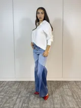 Pantalón de jean acampanado con cintura alta y diseño patchwork en tres tonos de azul.