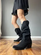 Botas de cuero color marrón, de caña alta y estilo cowboy.