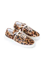Zapatillas bajas con estampado animal print de leopardo, cordones blancos y suela blanca.