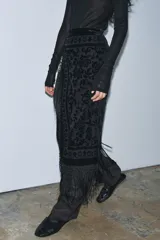 Falda midi negra de terciopelo con jacquard floral y flecos en el ruedo.