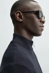 Cárdigan negro de punto con cuello perkins, cierre frontal con cremallera, manga larga y corte regular fit.