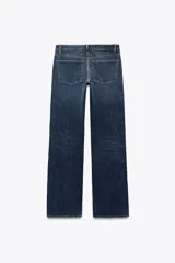 Jeans de mezclilla azul oscuro con efecto lavado, tiro bajo y pierna ancha extra larga. Modelo de cinco bolsillos con cierre frontal de cremallera y botón metálico.