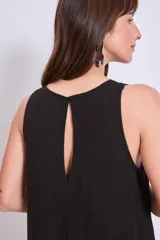 Vestido negro de corte holgado y largo a la rodilla, con cuello redondo y sin mangas. Presenta bordados florales en el escote y bolsillos laterales.