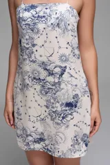 Vestido corto de tirantes finos, con estampado zodiacal en tonos amarillo, marrón y azul sobre fondo blanco.