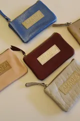 Monederito celeste metalizado de cuero, con forro de tela, ideal para tarjetas y monedas.