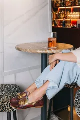 Zapato blucher de cuero con estampado animal print en tonos marrones y dorados, con cordones finos color borgoña y detalle de flor en el extremo del cordón.