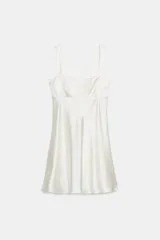 Vestido corto de satén color blanco, con escote recto, tirantes anchos y detalle de lazo en la espalda.