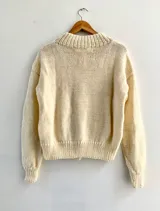 Cárdigan color crema de lana tejida con cuello redondo y botones de madera.