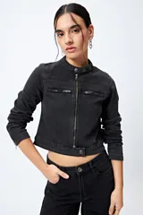 Campera entallada de denim con estampado animal print de cebra en tonos beige y negro. Tiene cuello mao con broches metálicos, cierre frontal con cremallera, bolsillos con cierre en el pecho y mangas largas con puños con cierre.