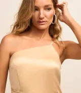 Vestido corto color dorado, de satén, con tirantes finos y escote asimétrico. Presenta un lazo lateral.