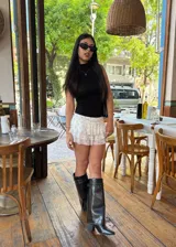 Botas de caña alta negras con hebillas plateadas y tachas.