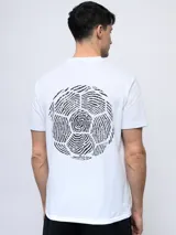 Remera color crema de corte clásico con cuello redondo y estampado en la espalda de una huella digital con forma de pelota de fútbol y el logo de Umbro.