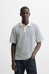 Polo de hombre con corte relaxed fit, cuello solapa con cierre frontal de botonadura y manga corta. Diseño a rayas horizontales en color crema y azul marino.