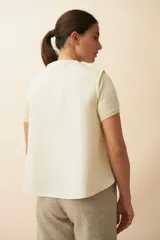 Chaleco marrón con solapas amplias y terminaciones envivadas. Diseño reversible y sin mangas.