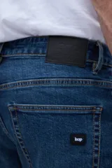 Jean de denim azul oscuro, corte slim fit, entallado en caderas y muslos, ajustado levemente desde la rodilla hasta el tobillo.