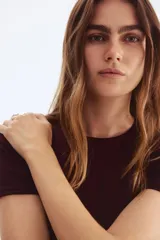 Remera de manga corta color borgoña, de punto elástico y corte ajustado con cuello redondo.