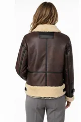 Campera estilo aviador de cuero sintético marrón con forro de piel sintética color crema en cuello, puños y dobladillo. Cierre frontal asimétrico con cremallera.