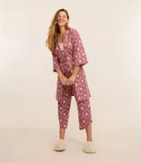 Conjunto de pijama de viscosa con estampado de caracolas, compuesto por una blusa de breteles finos con encaje en el escote, un pantalón capri con cintura elástica y una bata con lazo delantero.