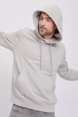 Hoodie tipo canguro color gris mineral, de manga larga con capucha y fit regular. Cuenta con un bolsillo y estampado de goma con tacto suave. Tejido Loop Back.