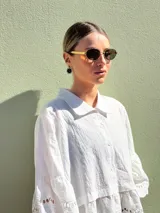 Camisa blanca de mangas 3/4 con detalles de broderie en las mangas y en el ruedo.