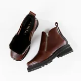 Bota de cuero vacuno color marrón, con interior forrado en corderito natural. Tiene suela de goma artesanal, punta cuadrada, cierre YKK en ambos lados y caña de 11cm.