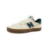 Championes New Balance color beige con detalles en verde y suela marrón. Presenta el logo de la marca en el lateral.