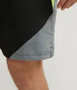 Bermuda deportiva negra con cintura elástica ajustable, recortes en gris en los laterales y vivos en amarillo flúor.