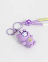 Llavero con dije de osito lila con un patito de goma en su capucha y llavero con dije de flor lila y strap de silicona con la inscripción "Luck Day".