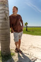 Remera tejida color crudo con cuello redondo con borde verde, mangas cortas y bolsillo en el pecho. Corte holgado.