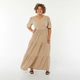 Vestido largo color beige de tejido gofrado, con escote cruzado en V, mangas cortas abullonadas y falda amplia con corte en capas.