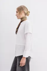 Remera blanca de algodón con mangas largas y calce recto. Diseño de doble capa, con remera de mangas rebatidas y camisa clásica debajo.
