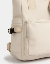 Mochila color crema de tela deportiva con manijas superiores, correas regulables, cierre superior, bolsillos laterales, bolsillo frontal con cierre y pouch estampado extraíble con solapa con hebilla de plástico para cerrado.