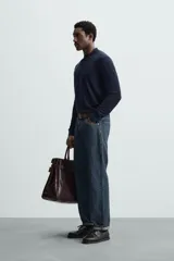 Polo azul marino de punto ligero tejido en hilatura con mezcla de seda y algodón. Cuello solapa con cierre frontal de botonadura, manga larga y acabados en rib.