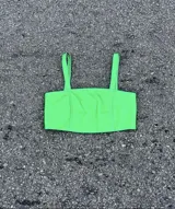 Top corto de cuero ovino color verde neón, con tirantes finos y diseño ajustado.