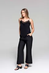 Camisola negra con breteles finos y escote en V, con detalles de encaje en el escote y los laterales.