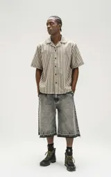 Bermuda denim larga color gris con efecto lavado, calce oversize, cintura con cinturón de ajuste y ruedo desflecado.