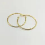 Par de aros tipo argolla de oro amarillo 18k con textura torneada.