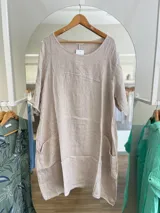 Vestido celeste de lino, corte oversize, con mangas cortas y bolsillos laterales.