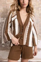 Saco tejido a rayas marrones, beige y blanco, con escote en V, mangas anchas y cierre frontal con botones.