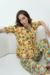 Camisa estampada con flores, de lino o popelina, con cuello en V y mangas cortas con volados. Se cierra con lazos en el frente.