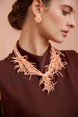 Collar corto de cuentas color salmón con diseño de flecos.