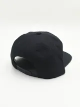 Gorro gris con visera plana y bordado frontal con la palabra "Brooklyn" en blanco.