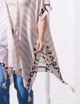 Kimono tejido con estampado abstracto en tonos beige, blanco y negro. Tiene mangas amplias estilo japonés y terminación de ruedo con borlas.