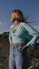 Saco de tejido ligero color beige, de manga larga y corte abierto, con cuello redondo.