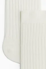 Par de medias de caña media color blanco, tejidas en punto acanalado con borde superior elástico.