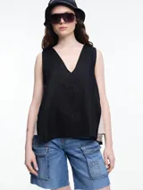 Top sin mangas negro en 100% lino, con escote en V y calce amplio. Los laterales en color contraste le dan un efecto visual envolvente.